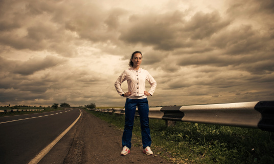 young sportive woman at stormy spring season roadside