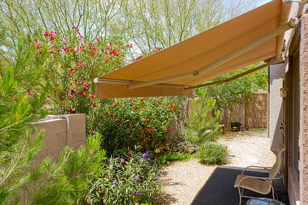 Awning Retracted over Doorway Arizona backyard with automatic retractable awning for extra shade awning stock pictures, royalty-free photos & images