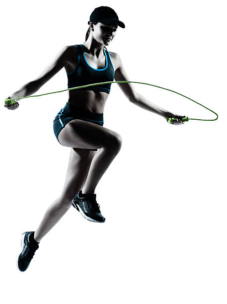 one caucasian woman runner jogger jumping rope in silhouette studio on white background