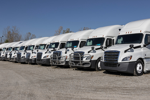 Indianapolis - November 2, 2023: Freightliner, Volvo and International Navistar Semi Tractor Trailer Trucks lined up for sale.