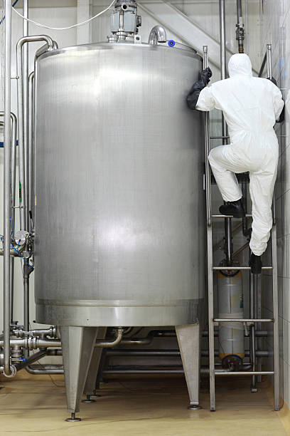 istock specialist in uniform climbing a ladder on industrial tank 177302125