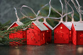 a fairytale village of unusual Christmas lights in the form of wooden toy houses with spruce branches. christmas decoration