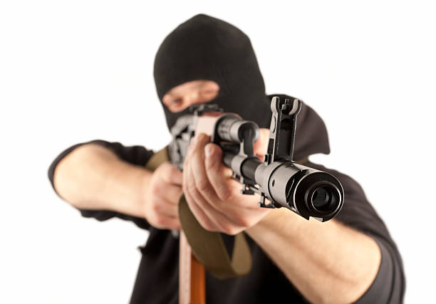 Man in mask with gun Man in mask with gun on white background firing squad stock pictures, royalty-free photos & images