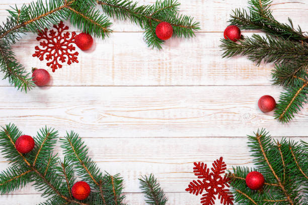 istock Christmas background - fir branches and red decorations on a white wood table. Flat layout, top view composition border with copy space 1773032813