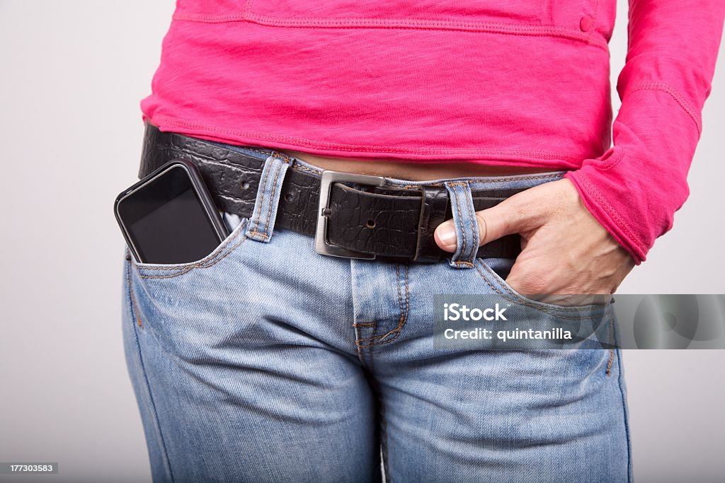 O telemóvel do bolso de ganga azul jovem - Royalty-free A usar um telefone Foto de stock