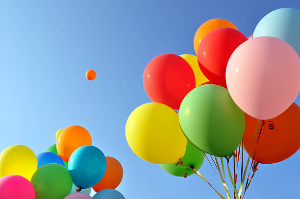 istock Bunches of multicolored balloons released into blue sky 177305670