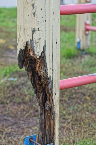 part of the structure on the street on the sports ground from the stairs with a rotten broken yellow brown wooden pole