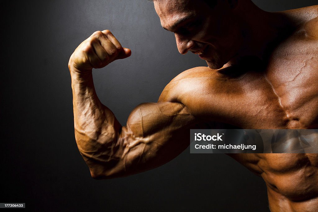 strong bodybuilder posing on black strong bodybuilder posing on black background Muscular Build Stock Photo