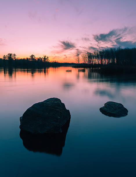 Petawawa Point "A beautiful sunset.  Waters perfectly smoothed by the long exposure.  Partially submerged rocks create harmony, beauty, and peace." ottawa river stock pictures, royalty-free photos & images