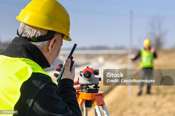 Two Surveyors In Reflective Gear And Tools Outdoors Stock Photo - Download Image Now