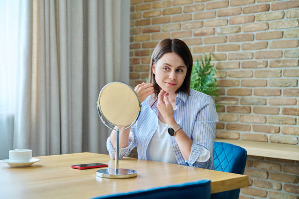 istock Young happy brunette looking at her face in mirror 1773070371
