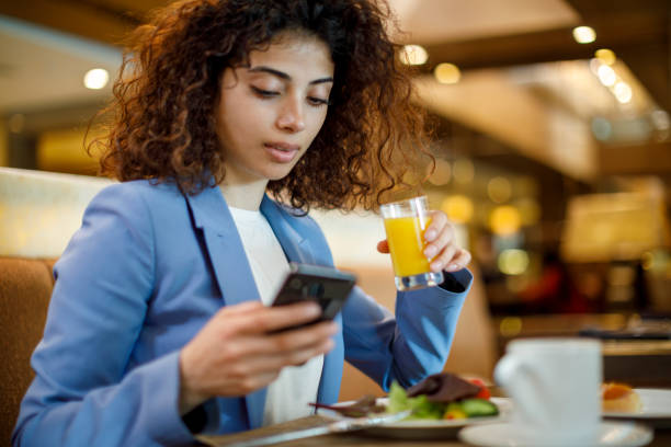 istock Businesswoman using mobile phone while having breakfast in hotel restaurant 1773071939