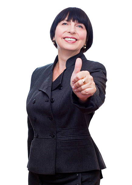 Mature business woman showing thumbs up, OK sign. stock photo