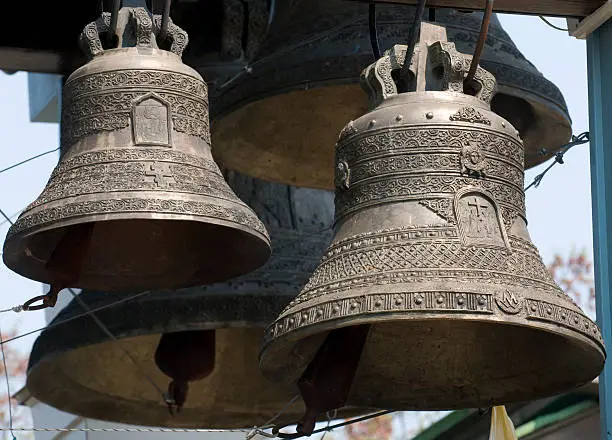 These are bells of Orthodox church-tower. The pattern and religious symbols are seen well on the bell surfaces.