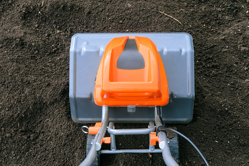 Electric cultivator on soil in vegetable garden. Top view close up.