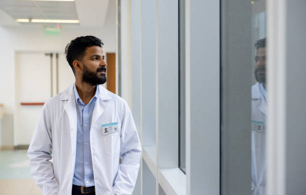 Tired doctor working at a hospital and looking through the window
