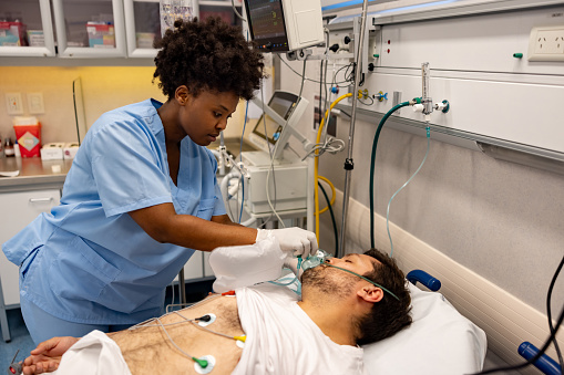 Nurse bagging a patient in the emergency room at the hospital - healthcare and medicine concepts