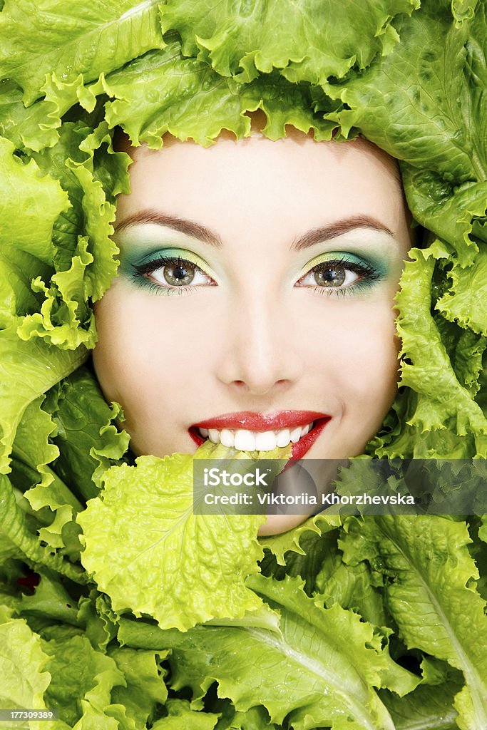 Rostro femenino con lechuga de hojas verdes frescas - Foto de stock de Adulto libre de derechos