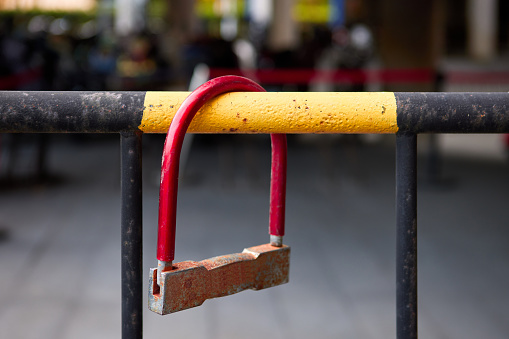 A red U-shaped lock hanging on the railing