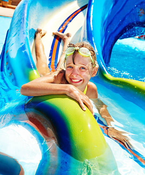 Child on water slide at aquapark. stock photo