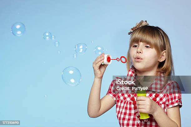 Girl Blowing Soap Bubbles Stock Photo - Download Image Now - Bubble Wand, Blue Background, Child