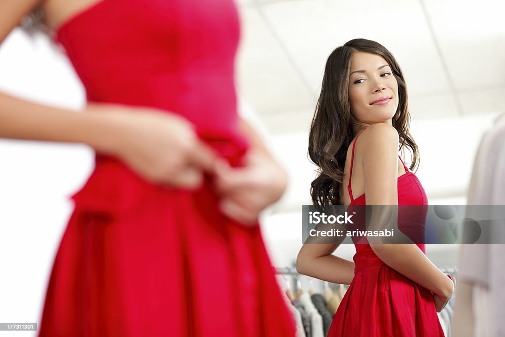 Girl trying dress Girl trying dress in looking in mirror cheerful and happy. Cute beautiful mixed race Asian / Caucasian young woman oin red dress. Dress Stock Photo