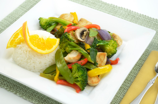 Chicken stir fry with rice on square white plate