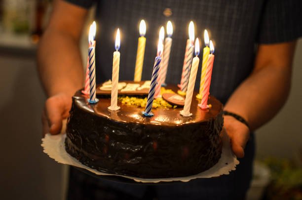 istock Man holding a birthday cake with burning candles on it 1773120109