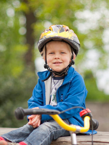 istock Little caucasian boy with helmet sitting behind his bicycle 177312156