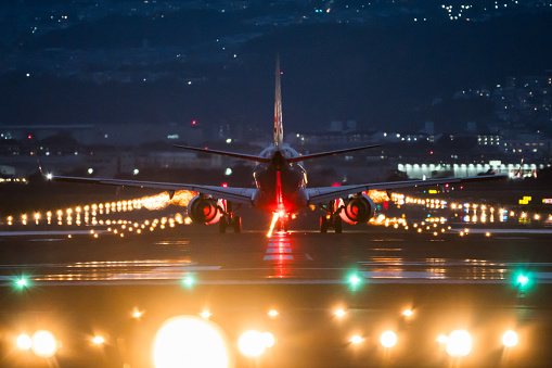 Large commercial airplane landing or take off on airport runway in Osaka at night. Journey abroad tourism, oversea travel, flight transit, air travel transport, airline business, or transportation industry