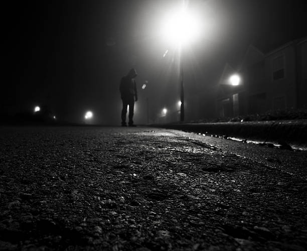Neighborhood Watch Alert A creepy figure standing in a residential area at night. creepy stalker stock pictures, royalty-free photos & images