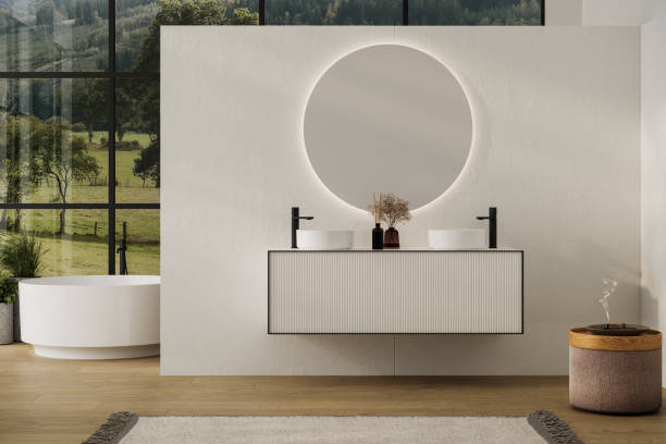 白い壁のエレガントなバスルーム、楕円形の鏡付きの白い洗面台、バスタブ、シャワー、植物、寄木細工の床。自由奔放に生きるスカンジナビアのバスルーム。