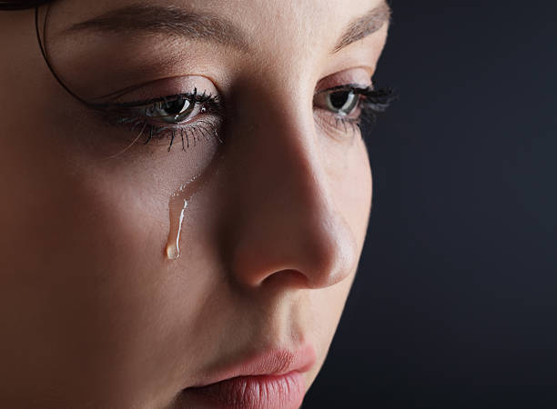 Beautiful young girl with a tear on her cheek stock photo