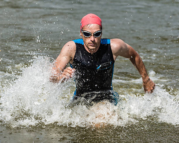 istock triathlete running out of the water 177315872
