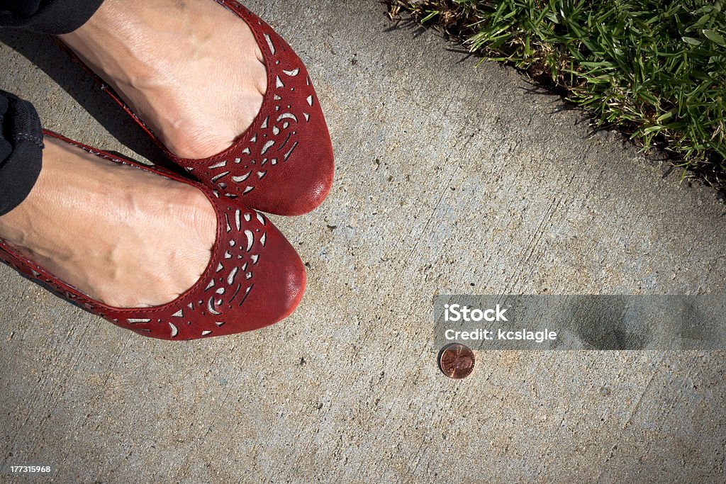 Girl Finds a Penny A girl in red shoes finds a penny on the sidewalk. Pick it up and you'll have good luck all day! US Penny Stock Photo