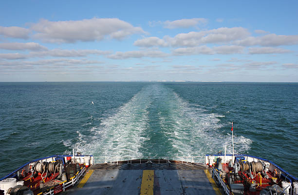 Ferry Boat leaving UK land from Dover to Calais Ferry Boat traveling at full speed toward Calais in a clear bright day. ferry dover england calais france uk stock pictures, royalty-free photos & images