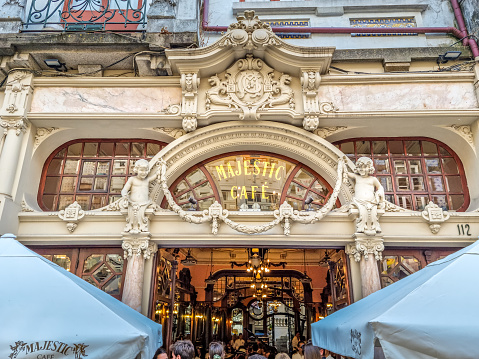 Porto, Portugal - 11 August, 2023: People enjoying the Majestic cafe. The traditional place  was designed to look like a Parisian cafe in the Art Nouveau style.