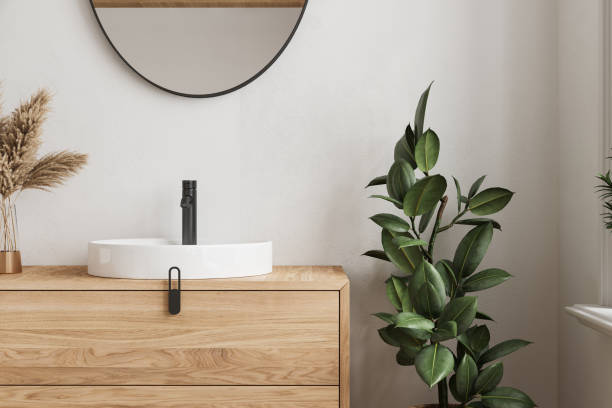 nahaufnahme eines bequemen waschbeckens mit rundem spiegel, der auf einer holzarbeitsplatte in einem modernen badezimmer mit weißen wänden steht - bathroom bathroom sink sink design stock-fotos und bilder