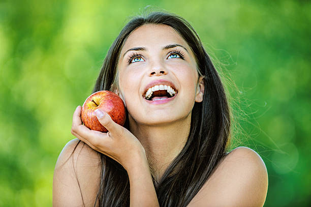 istock woman holding an red apple and smiling 177317425