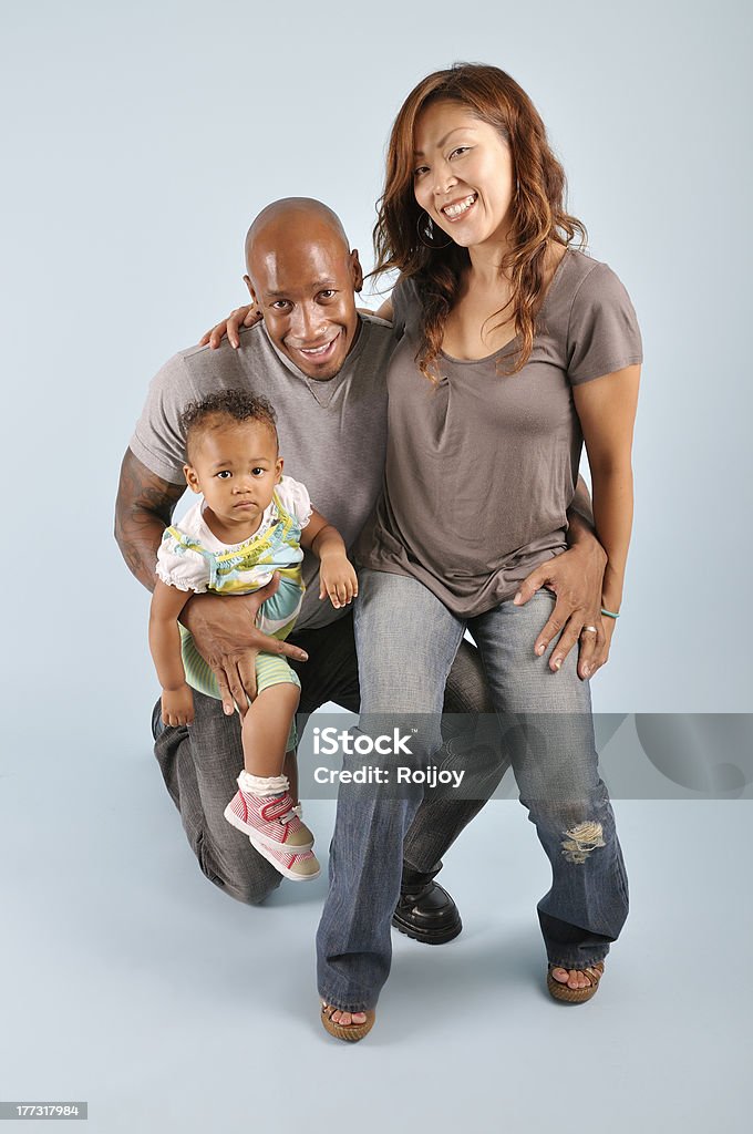 Young mixed family "Asian wife, African American husband posing with their mixed race infant girl." Adult Stock Photo