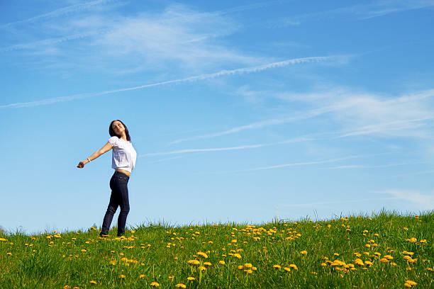 happy smiling woman dancing on a green meadow