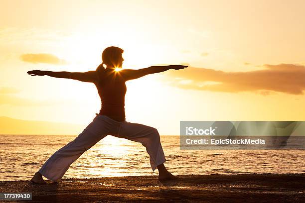 Photo libre de droit de Femme Pratiquant Yoga Au Coucher Du Soleil banque d'images et plus d'images libres de droit de Activité - Activité, Adulte, Coucher de soleil