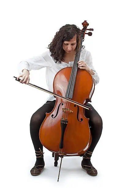 Young cellist siting and playing cello on white background