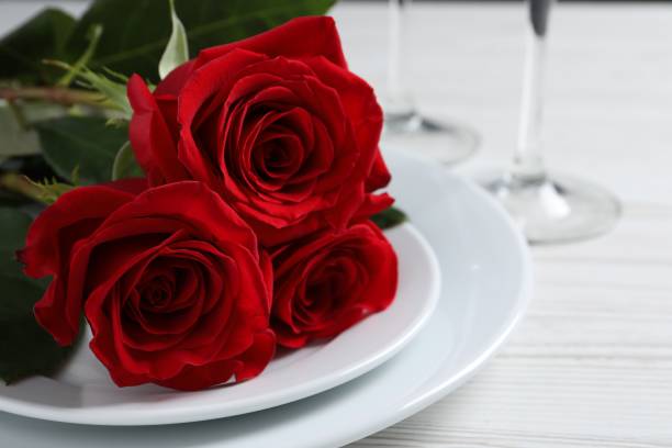 istock Beautiful place setting with dishware and roses for romantic dinner on white wooden table, closeup 1773198281