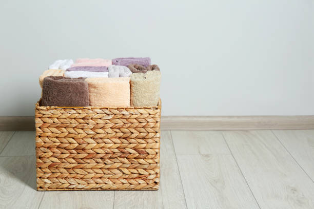 istock Wicker laundry basket with clean terry towels on floor indoors, space for text 1773199343
