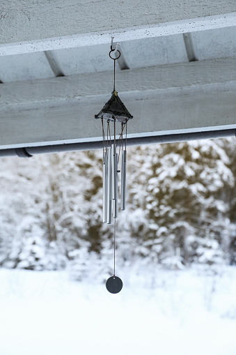 Stylish wind chimes hanging on winter day outdoors