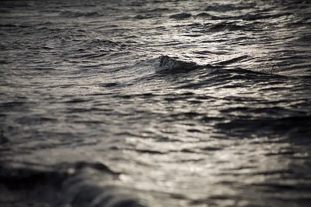 This photo shows the water surface of the baltic sea. It is grey and reflecting the dull sun.