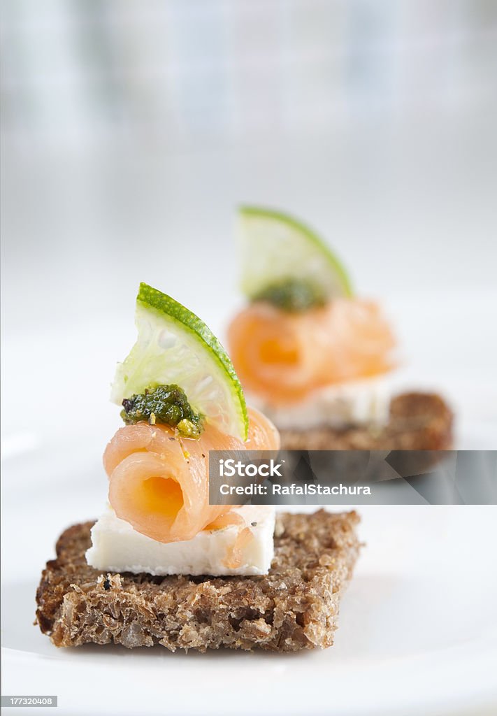 Salmon appetizer Brown bread salmon appetizer with feta cheese, lime and pesto Appetizer Stock Photo