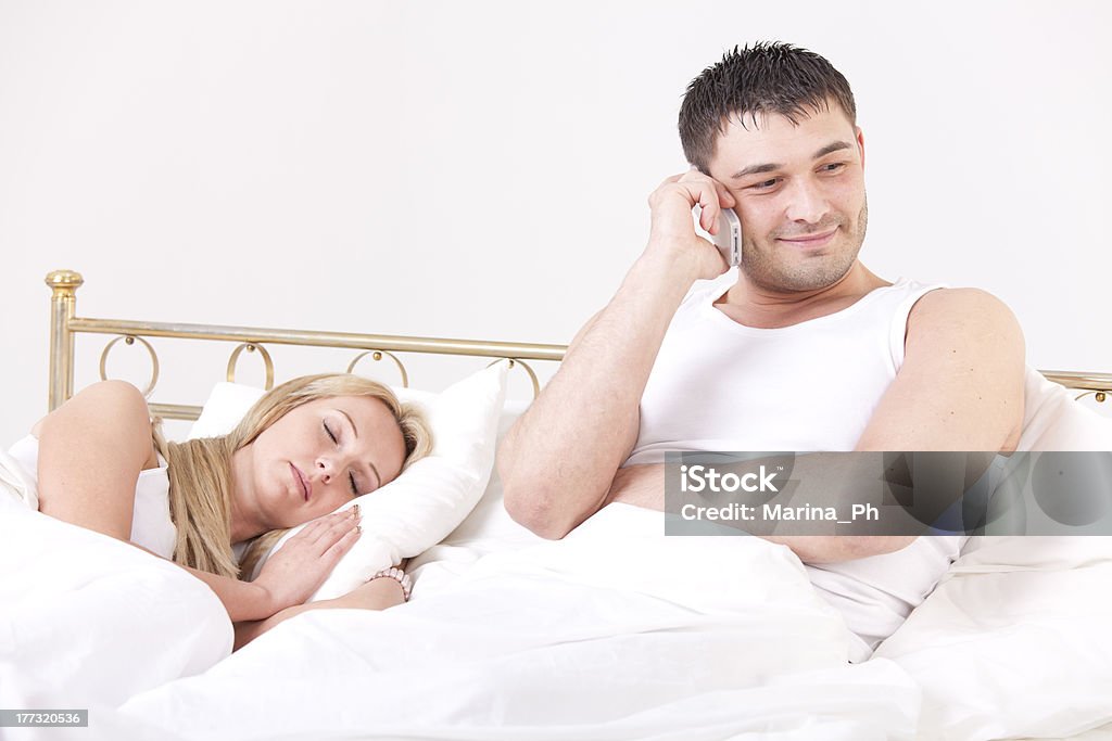 man cheating while woman sleeping couple in bed - man cheating while a woman sleeping 20-29 Years Stock Photo