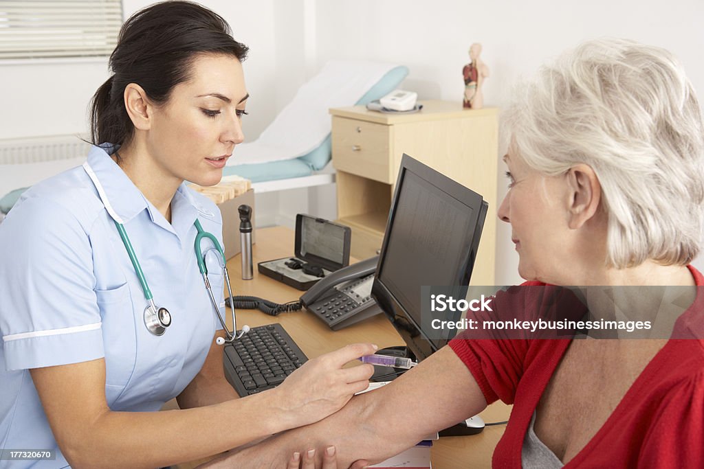 Великобритания медсестра, давая инъекций на пожилая женщина - Стоковые фото Вакцинация роялти-фри